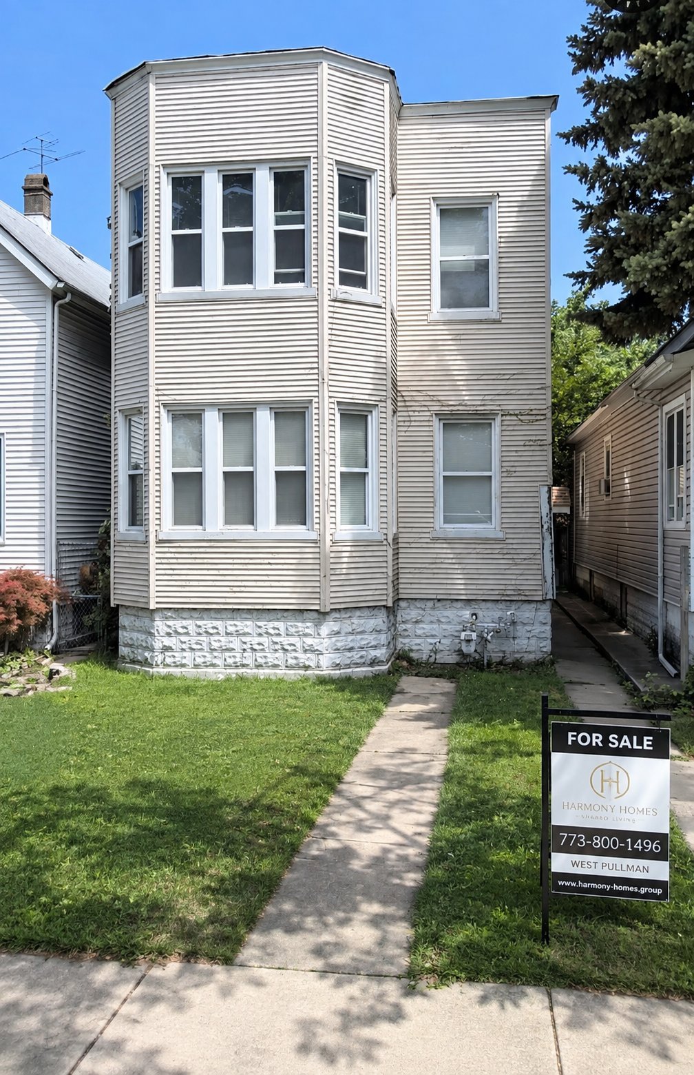 White corner two-story house with vinyl siding and large front windows in Roseland Chicago