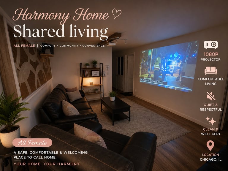 Cozy shared living room with black furniture, warm lighting, and movie projected on wall. Harmony Home all-female residence in Chicago.